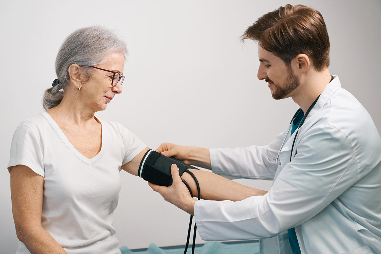 Arzt untersucht Blutdruck der Patientin im regionalen Versorgungszentrum